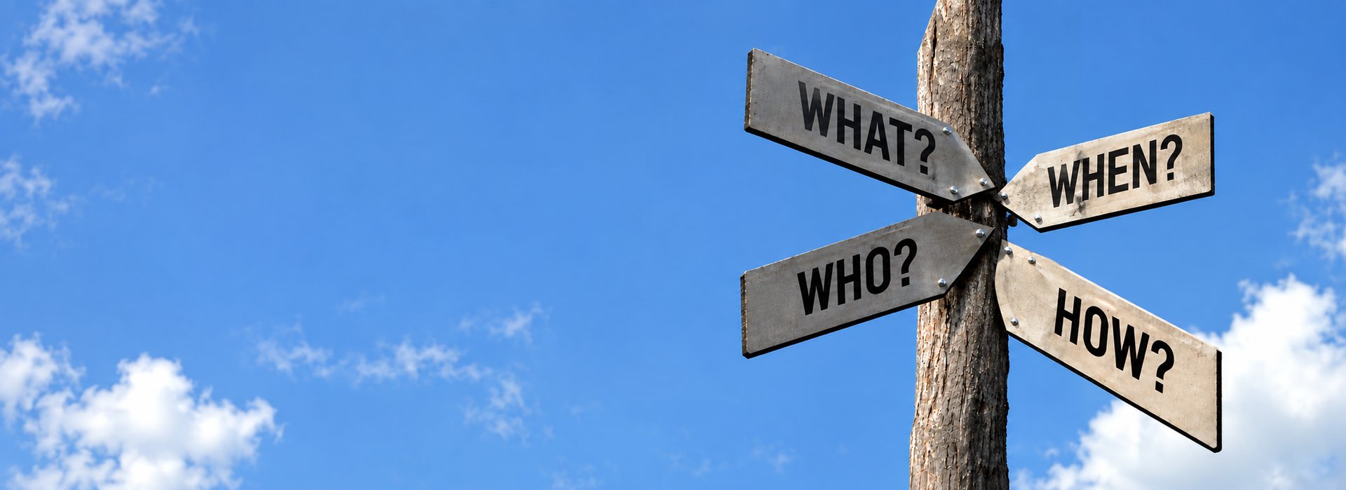 Signpost – What, When, Who, How Wooden signpost against a blue sky with clouds, showing directional signs reading "What?", "When?", "Who?" and "How?", symbolizing guidance and decision support